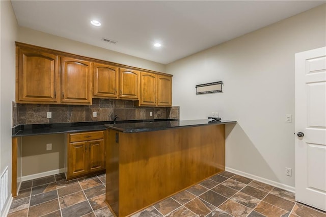 875 Clearview Dr, Lansing, KS 66043 - kitchen with dark countertops, brown cabinetry, tasteful backsplash, and recessed lighting