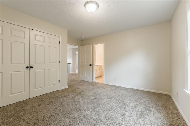 875 Clearview Dr, Lansing, KS 66043 - unfurnished bedroom with light carpet, a closet, a textured ceiling, and connected bathroom