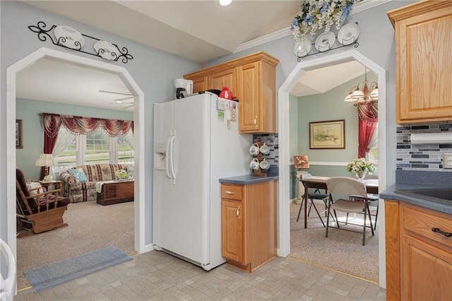 102 W Swenson Dr, Savannah, MO 64485 - kitchen featuring white fridge with ice dispenser, a chandelier, dark countertops, arched walkways, and crown molding