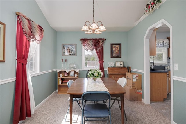 102 W Swenson Dr, Savannah, MO 64485 - dining room with a chandelier, light carpet, baseboards, and arched walkways