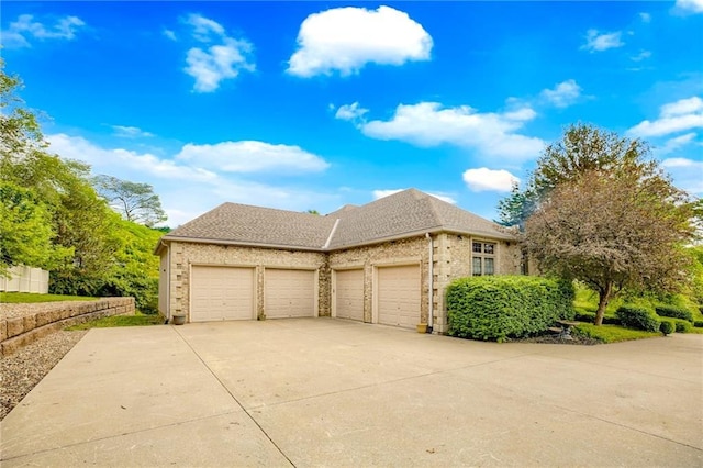 view of side of home with an attached garage, concrete driveway, brick siding, and a shingled roof