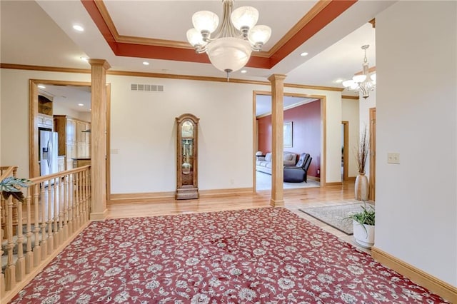 entryway featuring a chandelier, ornamental molding, decorative columns, baseboards, and recessed lighting