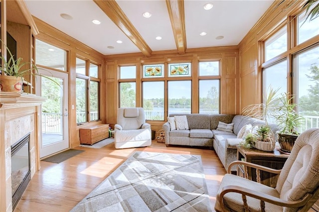 sunroom with healthy amount of natural light and a water view