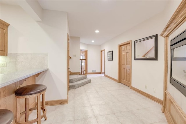 hall with recessed lighting, baseboards, stairs, and light tile patterned flooring