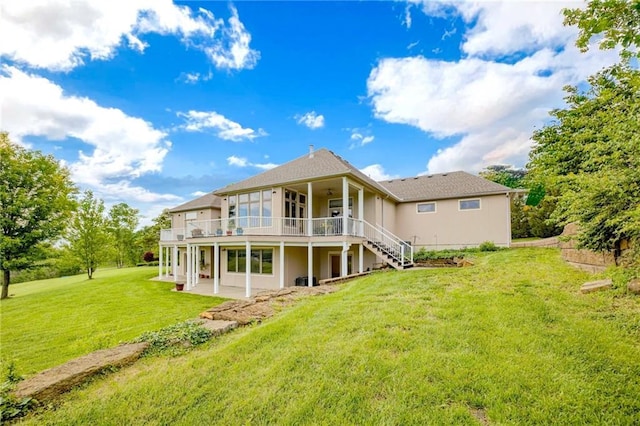 back of house featuring stairs, ceiling fan, a deck, a yard, and a patio