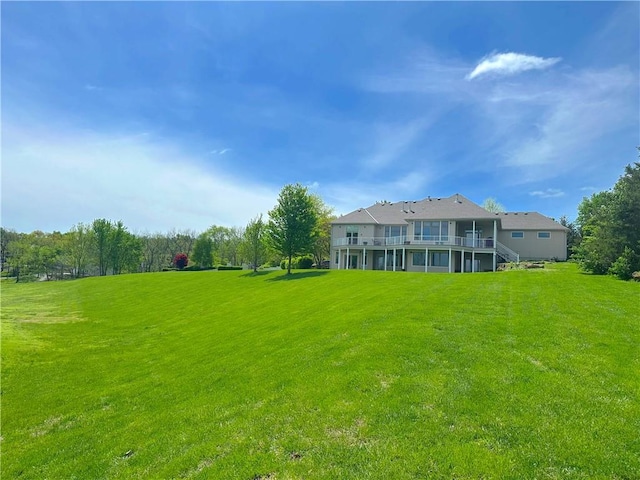 view of green lawn with a deck and stairway