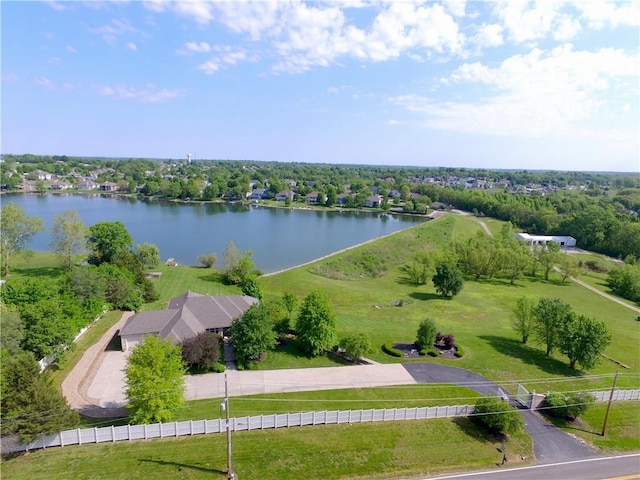 drone / aerial view of a nearby body of water and a tree filled landscape