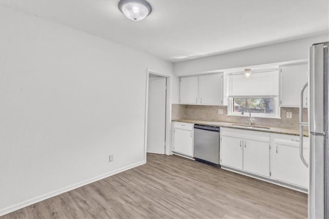 705 NW 88th Ter, Kansas City, MO 64155 - kitchen with light wood-type flooring, white cabinetry, a sink, appliances with stainless steel finishes, and backsplash