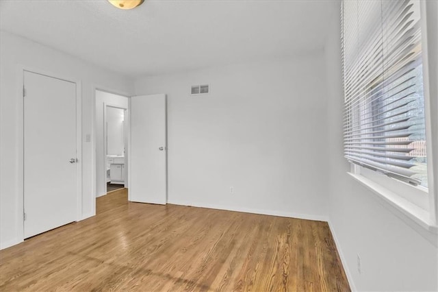 705 NW 88th Ter, Kansas City, MO 64155 - unfurnished bedroom with baseboards, visible vents, and light wood finished floors