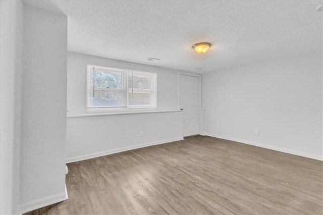 705 NW 88th Ter, Kansas City, MO 64155 - empty room featuring baseboards, a textured ceiling, and wood finished floors