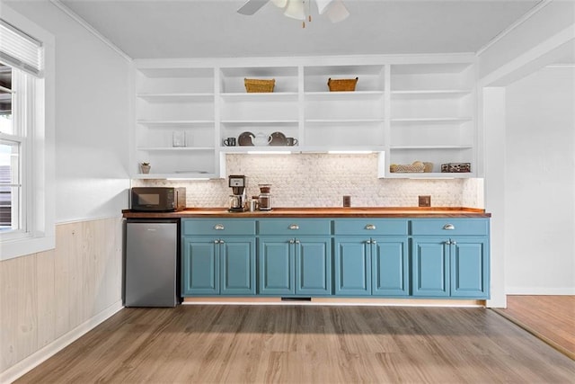 588 NW 105th Rd, Centerview, MO 64019 - bar with black microwave, wood finished floors, refrigerator, backsplash, and wainscoting