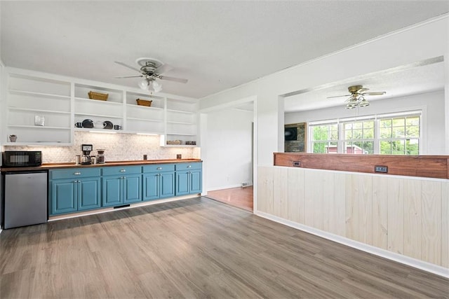 588 NW 105th Rd, Centerview, MO 64019 - kitchen with blue cabinets, ceiling fan, open shelves, and black microwave