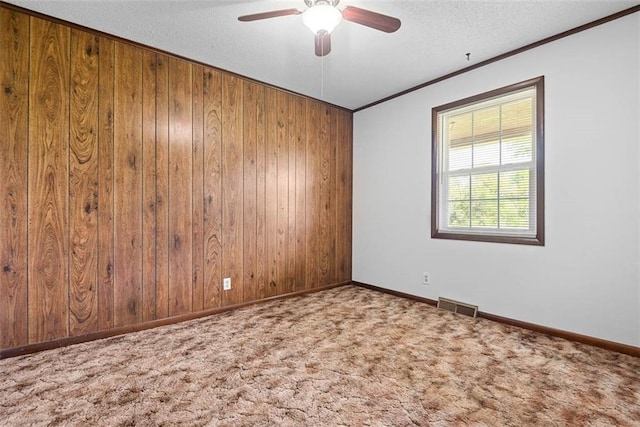 588 NW 105th Rd, Centerview, MO 64019 - carpeted empty room featuring a ceiling fan, crown molding, wooden walls, a textured ceiling, and baseboards
