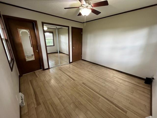 588 NW 105th Rd, Centerview, MO 64019 - unfurnished bedroom featuring light wood-style floors, ornamental molding, ceiling fan, and baseboards