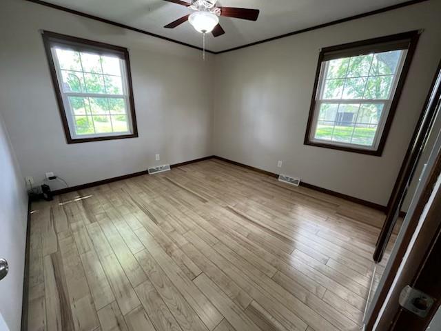 588 NW 105th Rd, Centerview, MO 64019 - spare room featuring a ceiling fan, baseboards, light wood-style floors, and ornamental molding