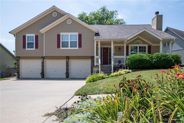 3616 Anchor Ct, Blue Springs, MO 64015 - view of front facade with covered porch, concrete driveway, an attached garage, and a chimney