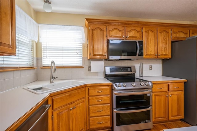 3616 Anchor Ct, Blue Springs, MO 64015 - kitchen featuring stainless steel appliances, brown cabinets, tasteful backsplash, and light countertops
