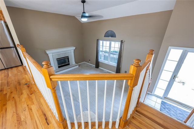 3616 Anchor Ct, Blue Springs, MO 64015 - stairs featuring a fireplace, ceiling fan, wood finished floors, and vaulted ceiling