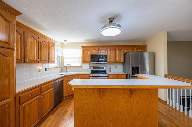 3616 Anchor Ct, Blue Springs, MO 64015 - kitchen featuring appliances with stainless steel finishes, a breakfast bar area, a kitchen island, light wood finished floors, and light countertops