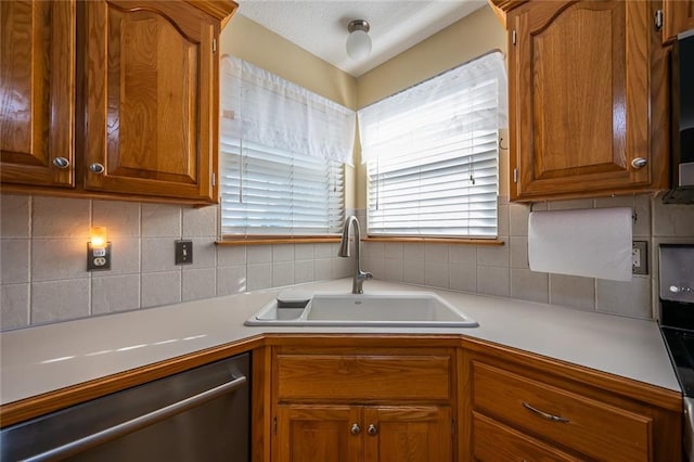 3616 Anchor Ct, Blue Springs, MO 64015 - kitchen with dishwasher, backsplash, light countertops, and brown cabinetry