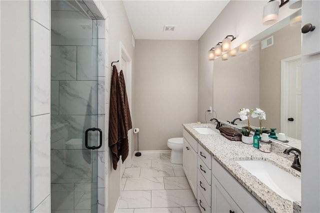 bathroom featuring marble finish flooring, a shower stall, toilet, double vanity, and baseboards