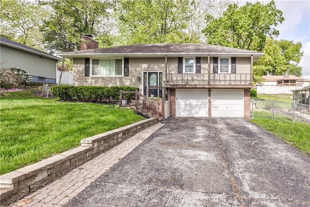 4328 S Brentwood St, Independence, MO 64055 - bi-level home with a front yard, a chimney, brick siding, an attached garage, and driveway