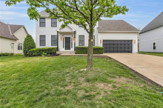 colonial inspired home featuring concrete driveway, a front lawn, and a garage