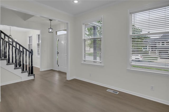 foyer with visible vents, crown molding, stairs, wood finished floors, and baseboards