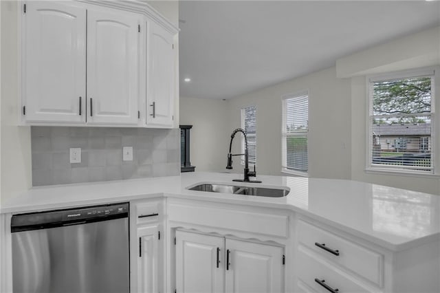 kitchen with white cabinets, a sink, dishwasher, light countertops, and tasteful backsplash