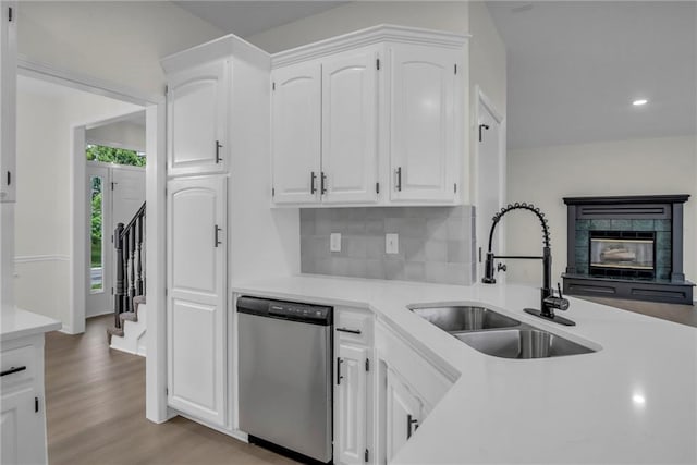 kitchen featuring white cabinetry, light wood-style floors, a sink, and dishwasher