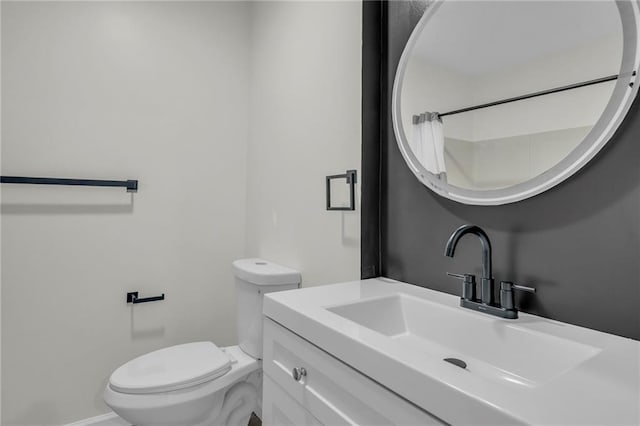 bathroom featuring vanity, baseboards, and toilet
