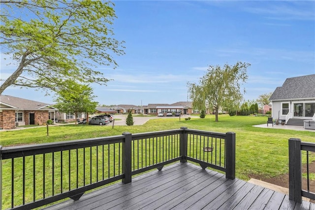 wooden deck featuring a residential view, a yard, and a patio area