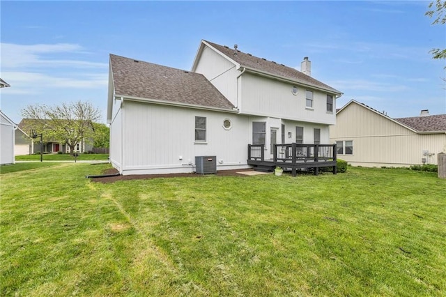 back of property featuring a lawn, a wooden deck, a chimney, and central AC