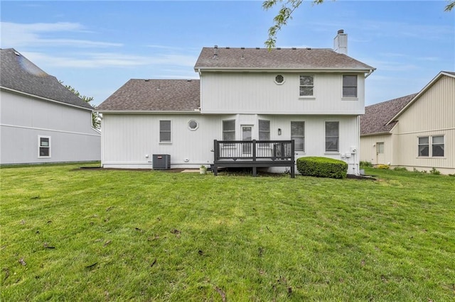 rear view of house featuring central air condition unit, a yard, a chimney, and a wooden deck
