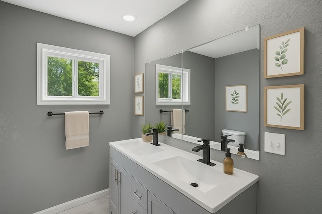 157 Clark Ave, Bonner Springs, KS 66012 - bathroom featuring double vanity, baseboards, and toilet
