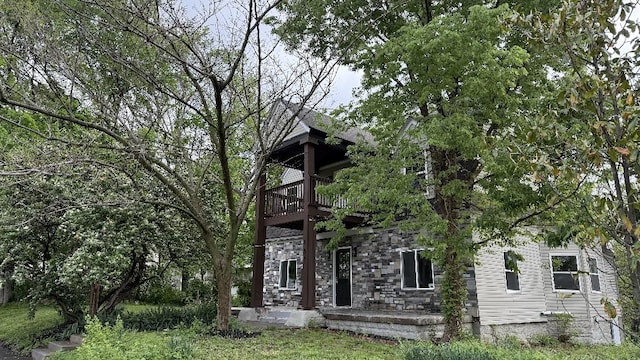 157 Clark Ave, Bonner Springs, KS 66012 - view of property hidden behind natural elements featuring a balcony and stone siding