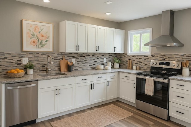 157 Clark Ave, Bonner Springs, KS 66012 - kitchen with stainless steel appliances, wall chimney exhaust hood, a sink, wood finished floors, and white cabinets