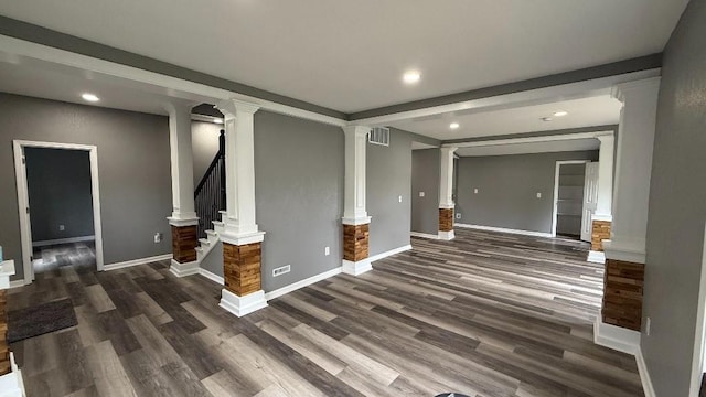 157 Clark Ave, Bonner Springs, KS 66012 - unfurnished living room featuring decorative columns, dark wood-type flooring, recessed lighting, baseboards, and stairs