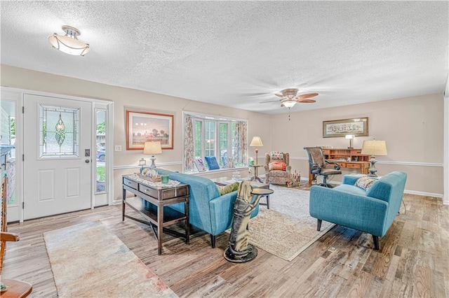 8739 Lafayette Ave, Kansas City, KS 66109 - living room featuring a textured ceiling, wood finished floors, a ceiling fan, and baseboards