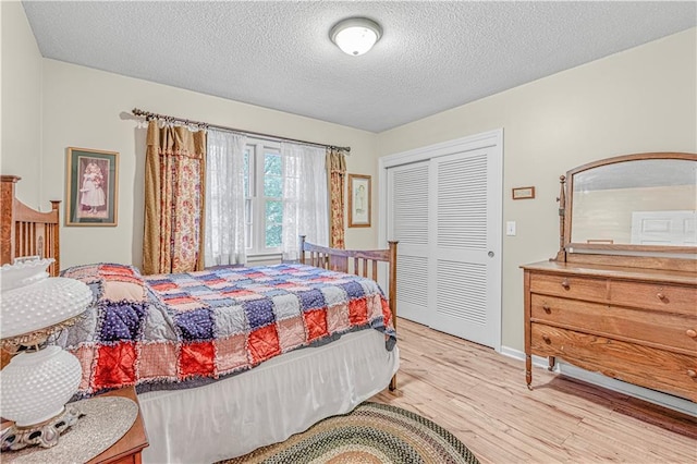 8739 Lafayette Ave, Kansas City, KS 66109 - bedroom with wood finished floors, a textured ceiling, a closet, and baseboards