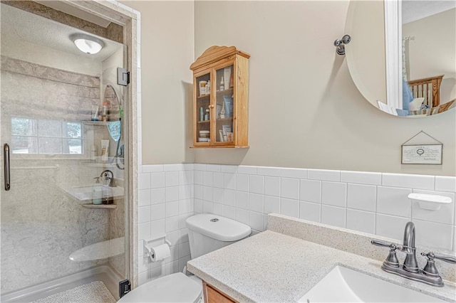8739 Lafayette Ave, Kansas City, KS 66109 - bathroom with tile walls, vanity, a shower stall, toilet, and a wainscoted wall
