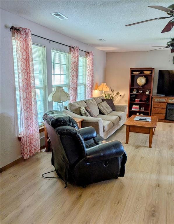 403 S 2nd St, Drexel, MO 64742 - living area with light wood-type flooring, a textured ceiling, and a ceiling fan