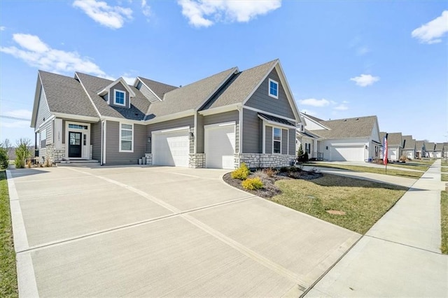 craftsman-style home with stone siding, driveway, an attached garage, and a front yard
