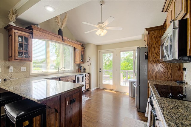 5912 NE Hidden Valley Dr, Lees Summit, MO 64064 - kitchen featuring stainless steel appliances, plenty of natural light, a sink, glass insert cabinets, and lofted ceiling