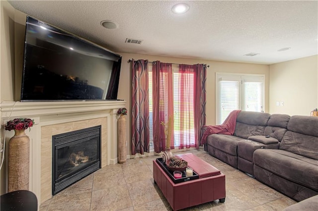 5912 NE Hidden Valley Dr, Lees Summit, MO 64064 - living room featuring a textured ceiling, a tiled fireplace, and recessed lighting