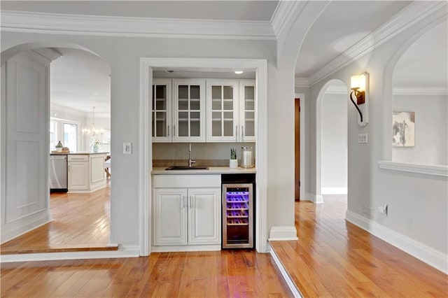 9000 W 104th St, Overland Park, KS 66212 - bar with arched walkways, light wood-style flooring, wet bar, and beverage cooler