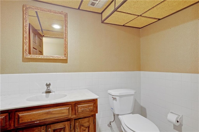 9000 W 104th St, Overland Park, KS 66212 - bathroom with visible vents, tile walls, wainscoting, vanity, and toilet