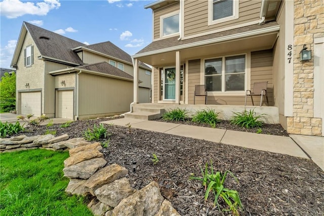 view of front of home featuring a garage, a porch, and stone siding