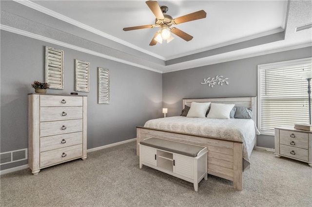 bedroom with visible vents, light colored carpet, ornamental molding, and a raised ceiling