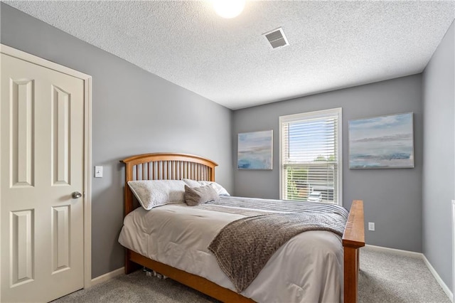 carpeted bedroom with a textured ceiling, baseboards, and visible vents